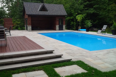 Pool house - large contemporary backyard stone and rectangular lap pool house idea in Toronto