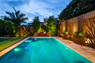 Großer Moderner Pool hinter dem Haus in rechteckiger Form mit Natursteinplatten in Sydney