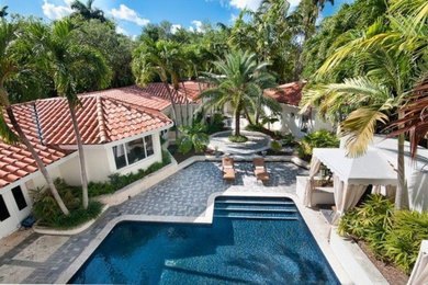 Modelo de casa de la piscina y piscina alargada mediterránea grande en forma de L en patio lateral con adoquines de piedra natural