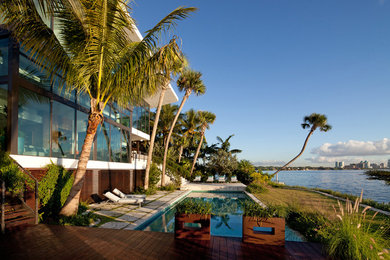 Inspiration for a large contemporary backyard rectangular lap pool remodel in Miami with decking