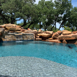 Immagine di un'ampia piscina naturale rustica personalizzata dietro casa con pedane