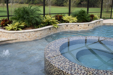 Ispirazione per una grande piscina coperta tradizionale personalizzata con una vasca idromassaggio e pavimentazioni in cemento