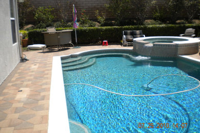 Hot tub - mid-sized transitional backyard concrete paver and custom-shaped natural hot tub idea in Los Angeles