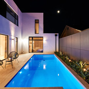 Photo of a mid-sized contemporary courtyard rectangular lap pool in Melbourne with concrete pavers.