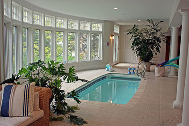 Imagen de piscina alargada clásica grande interior y rectangular con adoquines de hormigón