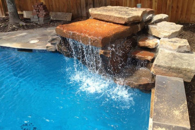 Imagen de piscina con fuente natural de estilo americano de tamaño medio a medida en patio trasero con adoquines de hormigón