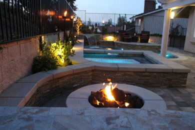 Imagen de piscina con fuente clásica de tamaño medio a medida en patio trasero con adoquines de hormigón