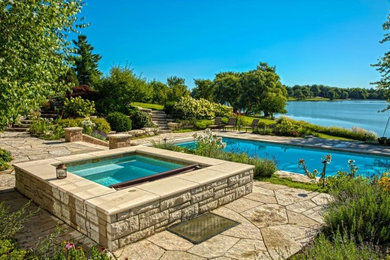 Idée de décoration pour une piscine naturelle et arrière craftsman de taille moyenne et rectangle avec un bain bouillonnant et des pavés en pierre naturelle.