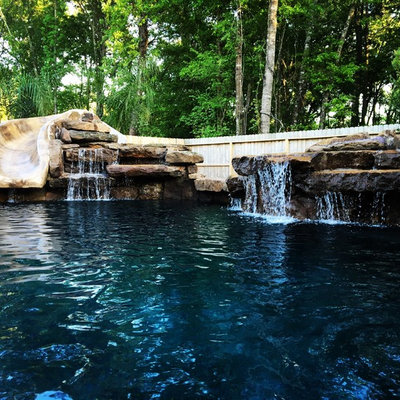 Mid-sized mountain style backyard stone and custom-shaped lap water slide photo in Houston