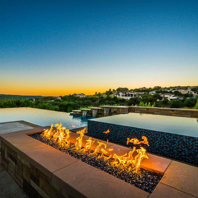 Trendy backyard concrete and custom-shaped infinity pool fountain photo in Austin