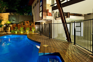 Cette photo montre une piscine naturelle et arrière moderne de taille moyenne et sur mesure avec une terrasse en bois.