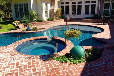 Diseño de piscinas y jacuzzis clásicos grandes a medida en patio trasero con adoquines de ladrillo