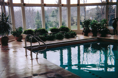 Foto de piscina alargada clásica renovada de tamaño medio interior y rectangular con losas de hormigón