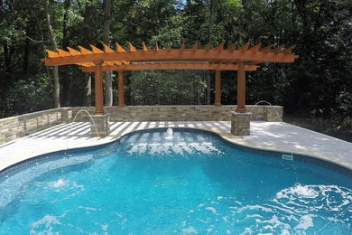 Inspiration for a large contemporary back custom shaped swimming pool in New York with concrete paving and a water feature.