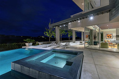 Inspiration for a mid-sized contemporary backyard concrete and rectangular infinity hot tub remodel in Las Vegas