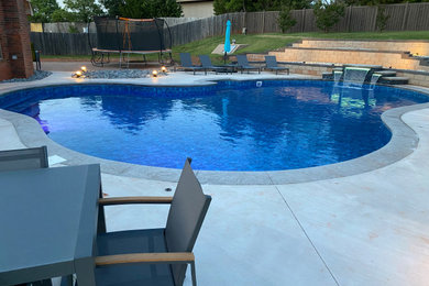 Example of a large minimalist backyard custom-shaped pool design in Oklahoma City