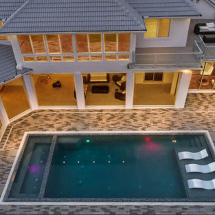 Foto de piscinas y jacuzzis románticos, grandes, rectangulares, en patio trasero, con adoquines de ladrillo