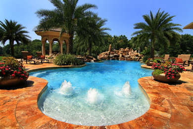 Inspiration for a tropical backyard custom-shaped pool fountain remodel in Other
