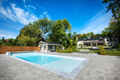 Example of a mid-sized trendy backyard brick and rectangular pool fountain design in Montreal