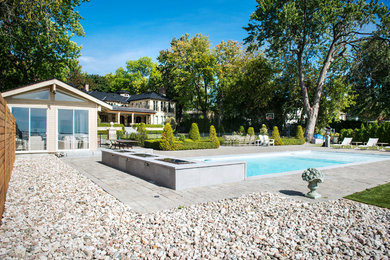 Example of a mid-sized trendy backyard brick and rectangular pool fountain design in Montreal