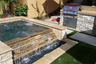 Diseño de piscina con fuente alargada tradicional de tamaño medio rectangular en patio trasero con adoquines de hormigón