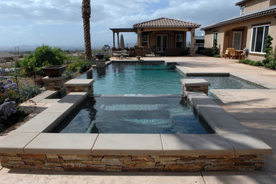 Foto de piscinas y jacuzzis infinitos actuales de tamaño medio a medida en patio trasero con adoquines de hormigón