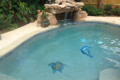 Example of a large classic backyard stamped concrete and custom-shaped natural pool fountain design in Miami