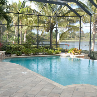 Idee per una grande piscina a sfioro infinito tropicale personalizzata dietro casa con una vasca idromassaggio e piastrelle