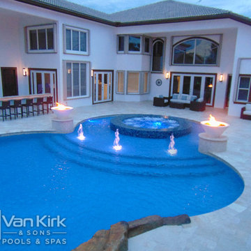 Custom Pool with Rock Waterfall and Wet Edge Spa During the Evening in Davie, Fl