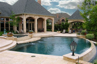 Foto de piscina natural grande a medida en patio trasero con adoquines de piedra natural