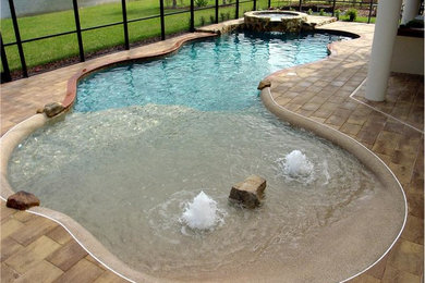 Modelo de piscina grande a medida en patio trasero con adoquines de piedra natural