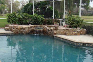Diseño de piscina grande a medida en patio trasero con adoquines de piedra natural
