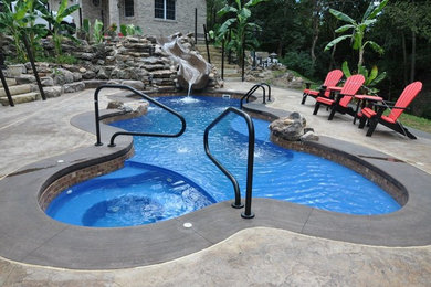 Mittelgroßer Uriger Pool hinter dem Haus in individueller Form mit Wasserrutsche und Betonplatten in St. Louis