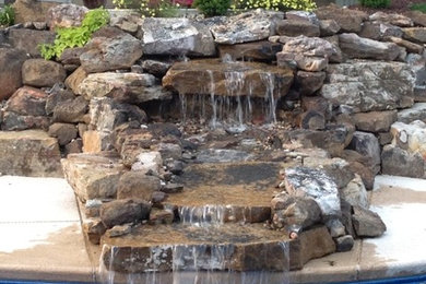 Diseño de piscina con fuente tradicional renovada de tamaño medio a medida en patio trasero con losas de hormigón