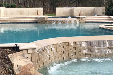 Imagen de piscina con fuente alargada tradicional renovada de tamaño medio a medida en patio trasero