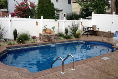 Photo of a medium sized classic back custom shaped swimming pool in New York with a water feature and concrete slabs.
