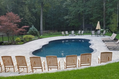 Inspiration for a medium sized classic back custom shaped lengths swimming pool in Boston with concrete paving.