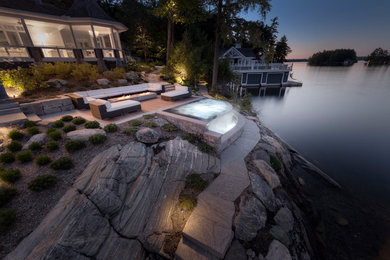 Inspiration for a mid-sized contemporary backyard concrete paver and custom-shaped infinity hot tub remodel in Toronto
