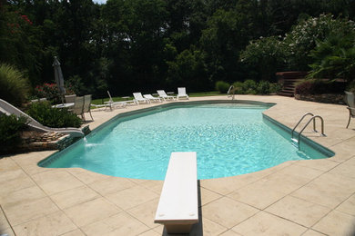 Large trendy backyard stamped concrete and l-shaped natural water slide photo in Atlanta