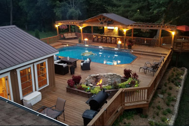 Cette photo montre une grande piscine hors-sol et arrière craftsman sur mesure avec une terrasse en bois.