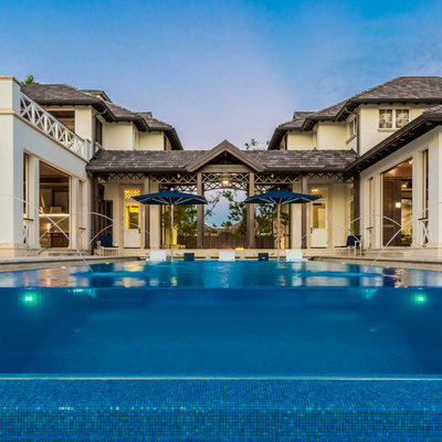 Pool fountain - tropical backyard tile and rectangular infinity pool fountain idea in Miami