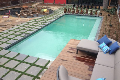 Diseño de piscina minimalista rectangular en patio trasero con adoquines de hormigón