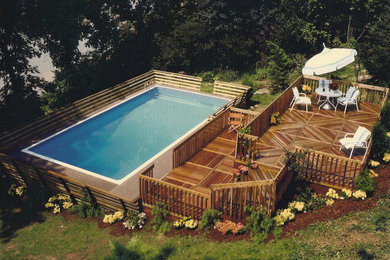Medium sized modern back rectangular above ground swimming pool in Detroit with decking.