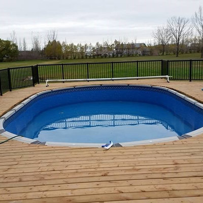 Example of a mid-sized arts and crafts backyard rectangular pool design in Other with decking