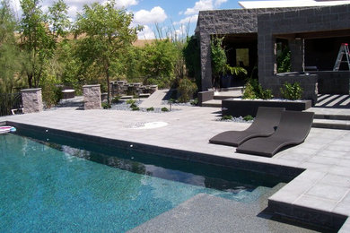 Idée de décoration pour une piscine arrière méditerranéenne avec des pavés en béton.