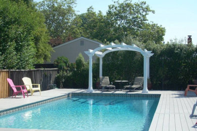 Ejemplo de piscina alargada clásica grande rectangular en patio trasero con entablado