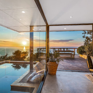 Mid-sized beach style backyard rectangular lap pool in Sydney with decking.