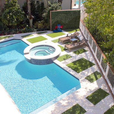Mid-sized island style backyard concrete paver and rectangular hot tub photo in Miami