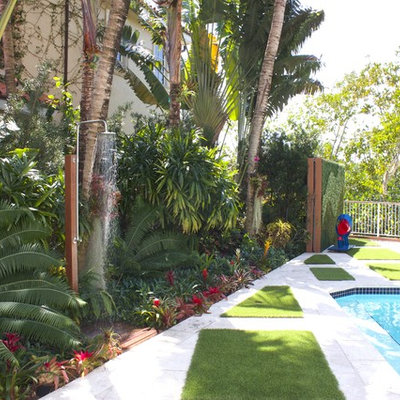 Mid-sized island style backyard concrete paver and rectangular hot tub photo in Miami