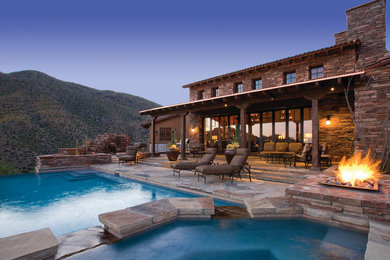 Imagen de piscina infinita rústica de tamaño medio a medida en patio trasero con adoquines de piedra natural